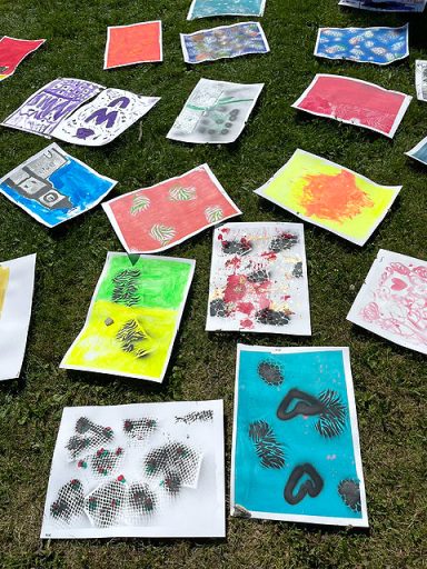 Viele bunte abstrakte Bilder auf einer Wiese liegend